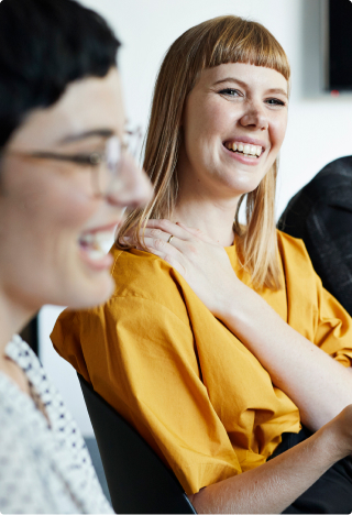 Teaserbild Leistungsportfolio - Lachende Kolleginnen in einem Meeting