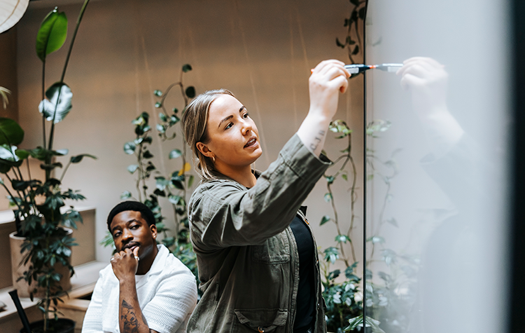 Woman writes on whiteboard