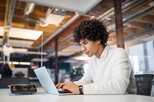 Mann arbeitet am Laptop