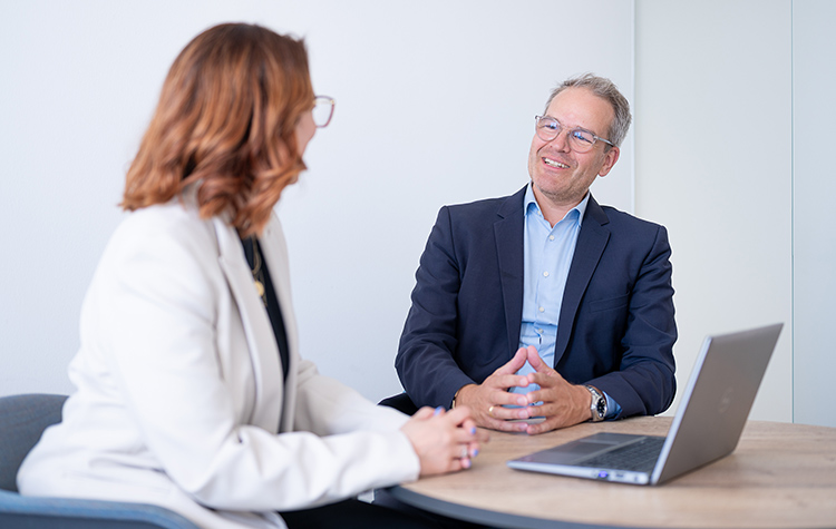 2 Personen unterhalten sich in einem Meeting angeregt