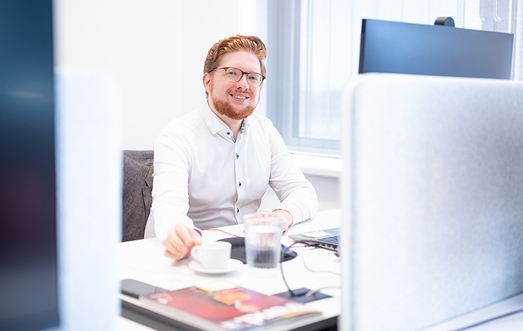 Mitarbeiter sitzt im Büro am Schreibtisch