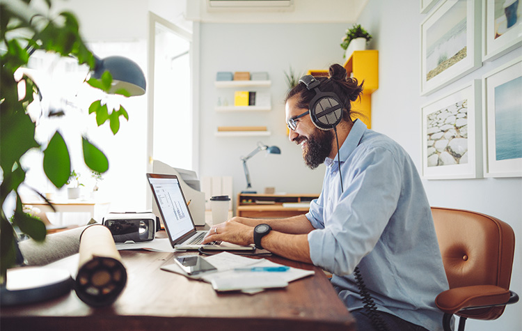 Frau in Business-Kleidung beugt sich lächelnd über einen geöffneten Laptop