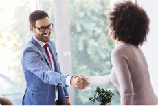 Two people shake hands cheerfully