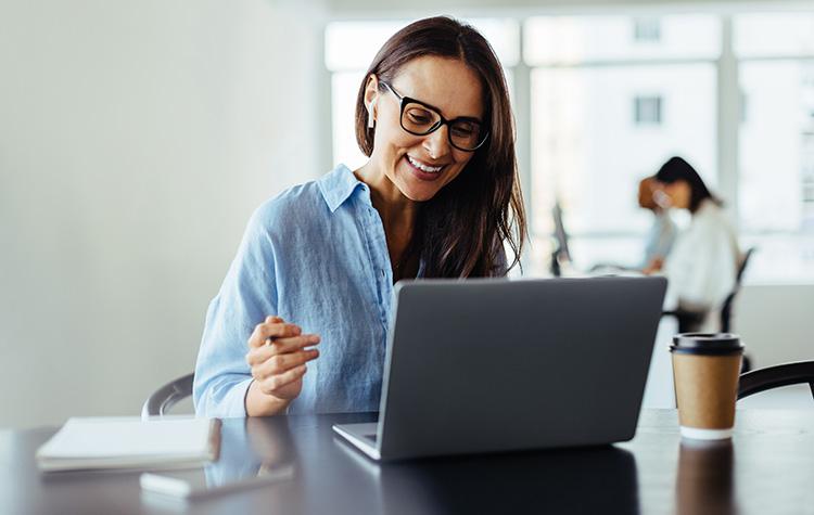 Woman smiling while working on her laptop