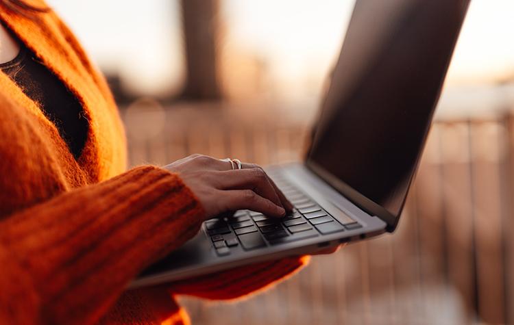Frau tippt auf ihrem Laptop